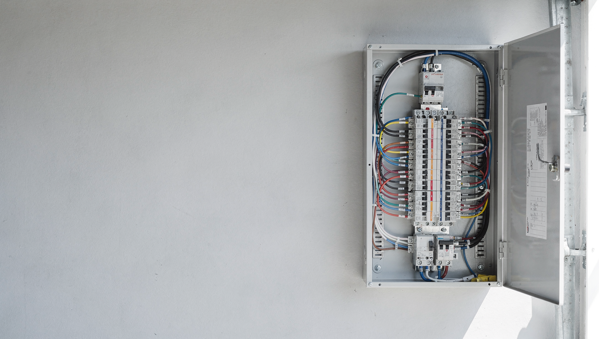 A brand-new residential electrical panel with neatly labeled breakers and organized wiring in bright daylight